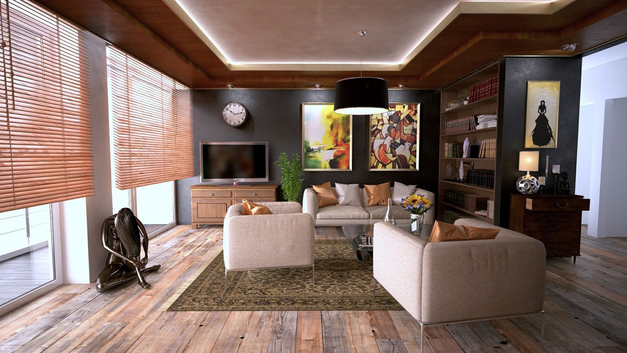 Two professionals in business casual attire shaking hands in the bright, modern living room of a beautiful home, representing a successful real estate agreement.