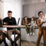 Professional real estate agent and a client attentively reviewing architectural blueprints together in a bright, modern se...